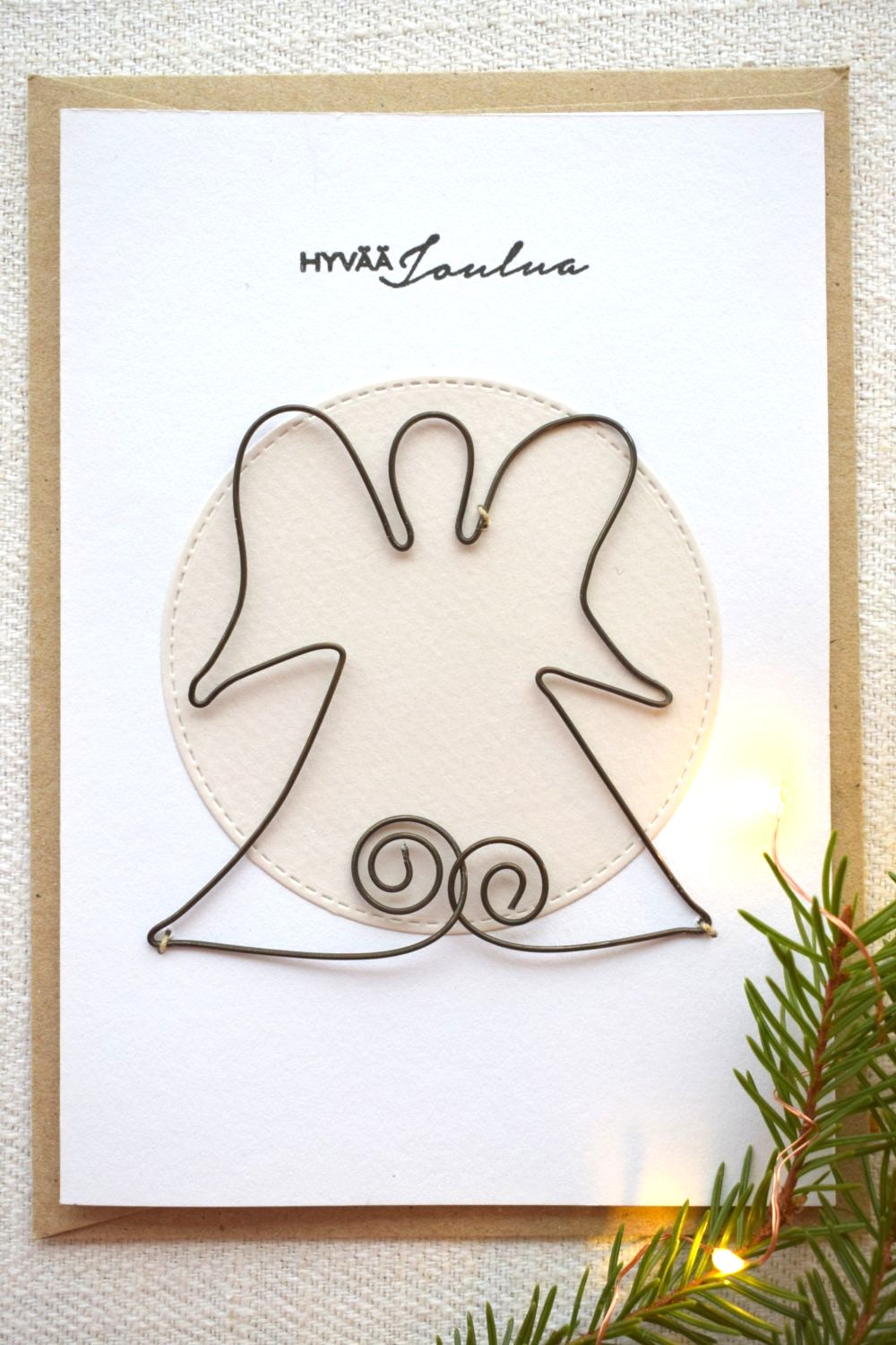 Käsintehty joulukortti jossa on rautalankaenkeli koristeena