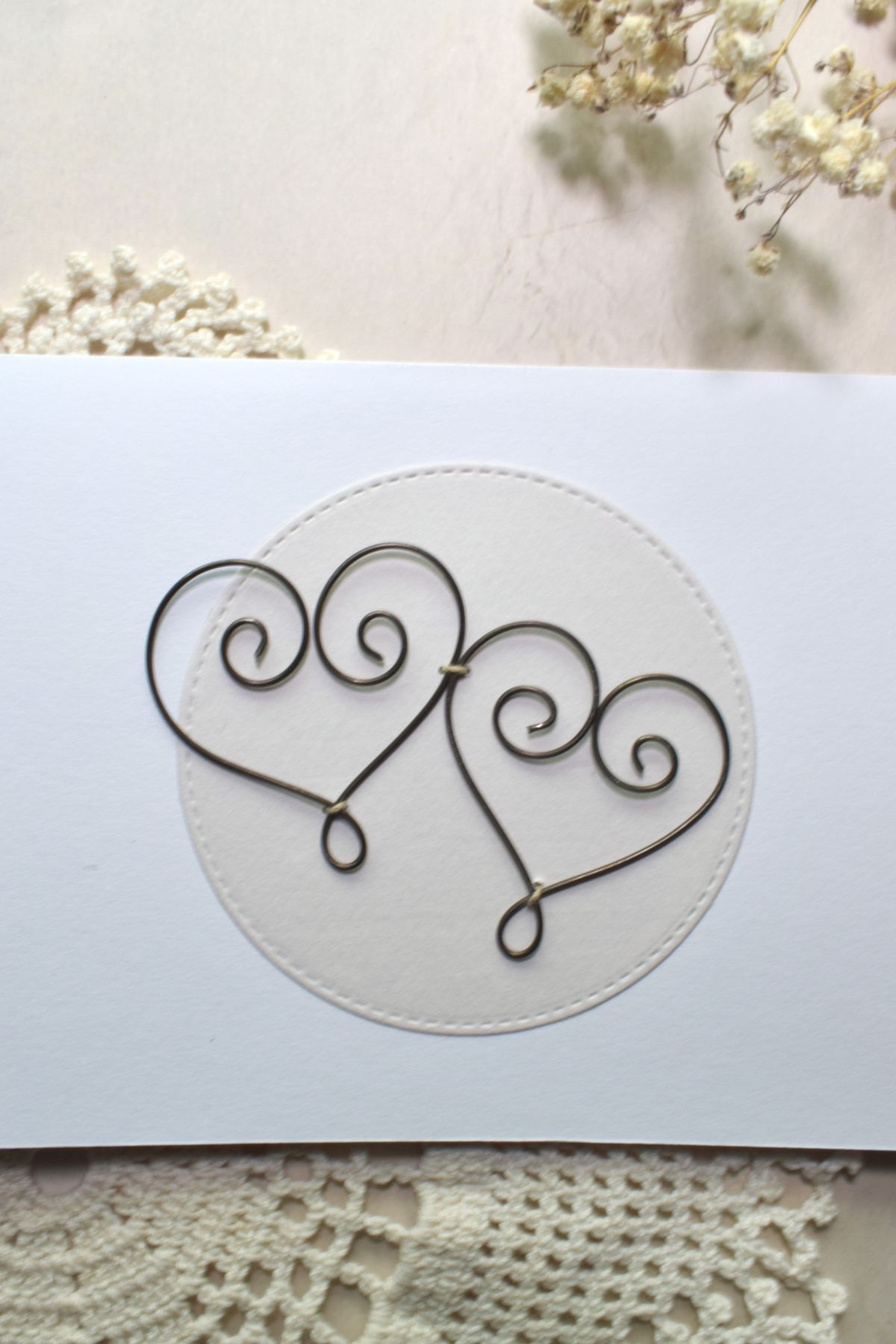 Kortti, jossa on kaksi rautalangasta muotoiltua sydäntä, sopii hää-tai kihlajaiskortiksi